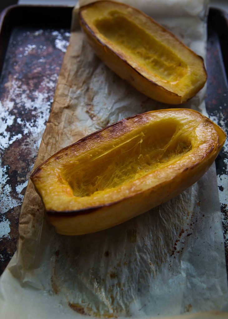 Roasting spaghetti squash for about an hour to start the Spaghetti Squash Gratin.